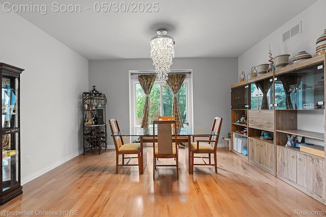 24516 Cavendish Ave E, Novi, MI 48375 - dining area featuring a chandelier, light wood-style flooring, and baseboards
