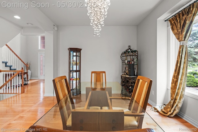 24516 Cavendish Ave E, Novi, MI 48375 - dining area featuring stairway, light wood finished floors, baseboards, and a chandelier
