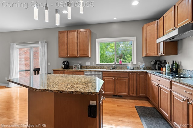 24516 Cavendish Ave E, Novi, MI 48375 - kitchen with under cabinet range hood, light wood finished floors, recessed lighting, stone countertops, and a sink