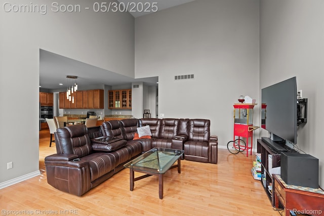 24516 Cavendish Ave E, Novi, MI 48375 - living area featuring a high ceiling, light wood finished floors, and baseboards