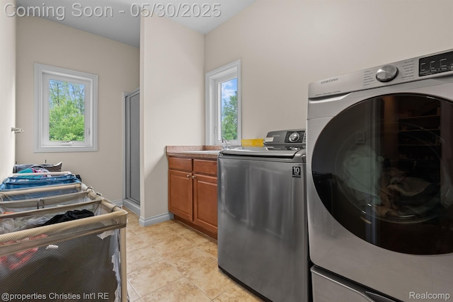 24516 Cavendish Ave E, Novi, MI 48375 - laundry area with cabinet space, washing machine and dryer, light tile patterned floors, and baseboards