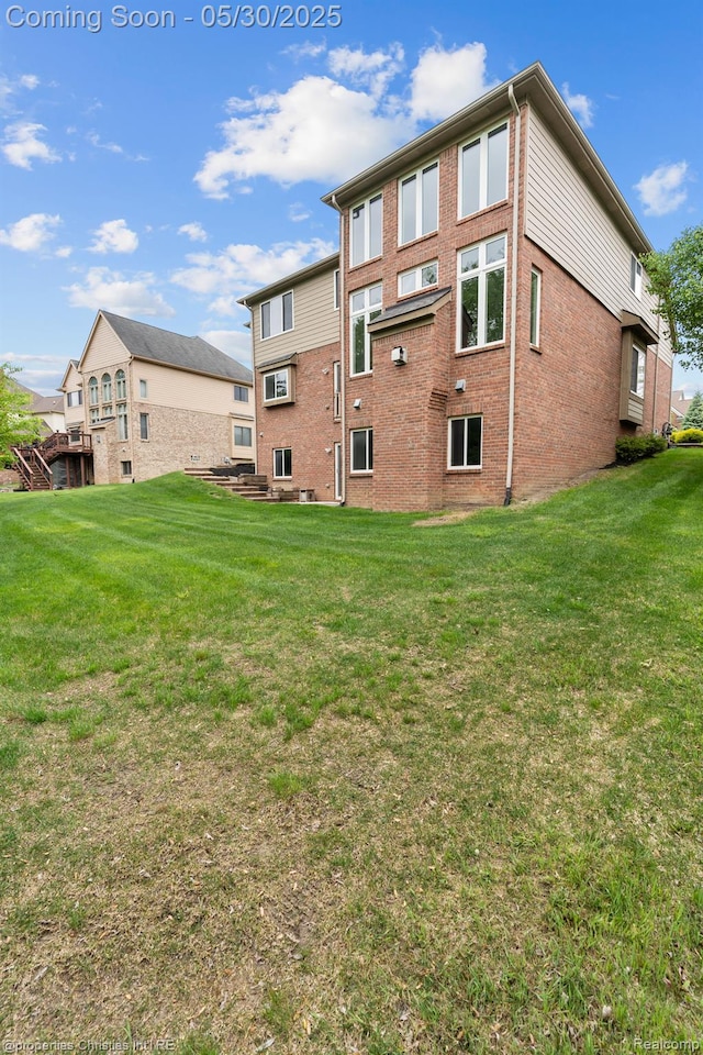 24516 Cavendish Ave E, Novi, MI 48375 - rear view of property featuring brick siding and a yard