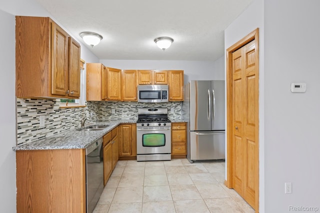 367 116th Ave, Martin, MI 49070 - kitchen featuring stainless steel appliances, backsplash, light stone counters, a sink, and brown cabinetry