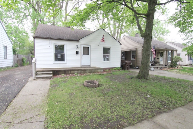 4521 Columbus St, Wayne, MI 48184 - bungalow with a porch, a shingled roof, driveway, and a fire pit
