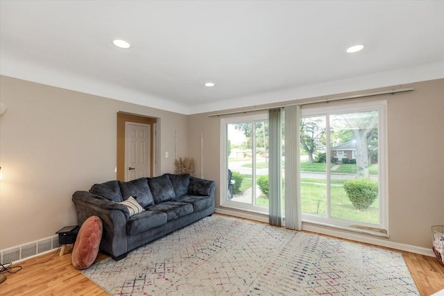 living room featuring wood finished floors, baseboards, and recessed lighting