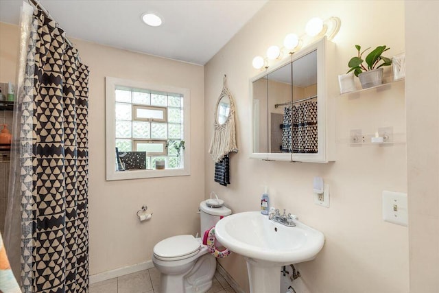 full bathroom with tile patterned flooring, toilet, a sink, a shower with curtain, and baseboards