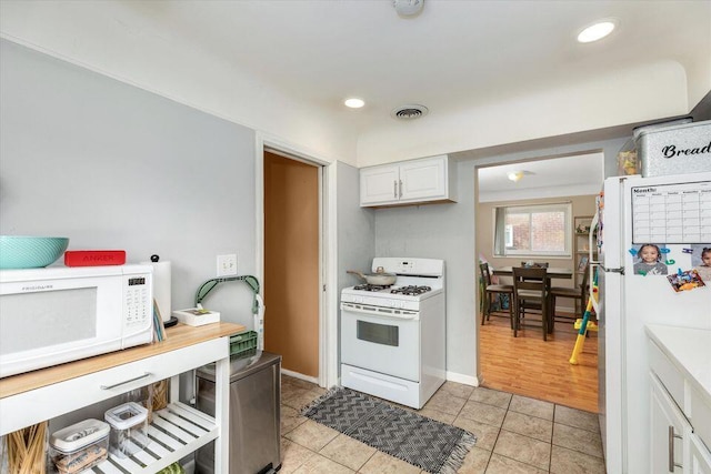 kitchen featuring white appliances, light tile patterned floors, white cabinets, recessed lighting, and light countertops