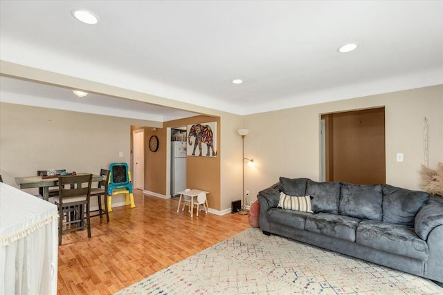 living area with light wood-type flooring, baseboards, and recessed lighting