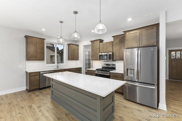 1404 Kimber Dr Unit 124, Lowell, MI 49331 - kitchen featuring appliances with stainless steel finishes, tasteful backsplash, light countertops, recessed lighting, and a center island