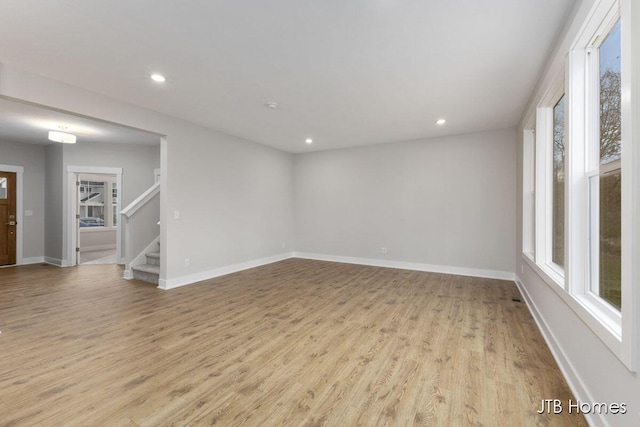 1404 Kimber Dr Unit 124, Lowell, MI 49331 - spare room featuring plenty of natural light, light wood finished floors, recessed lighting, and stairs