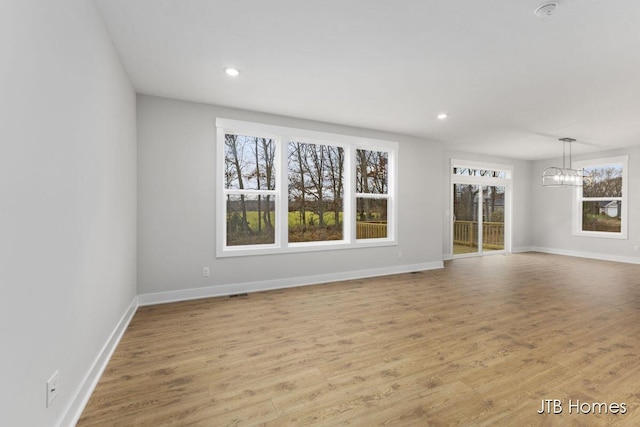 1404 Kimber Dr Unit 124, Lowell, MI 49331 - unfurnished living room featuring a chandelier, wood finished floors, and recessed lighting