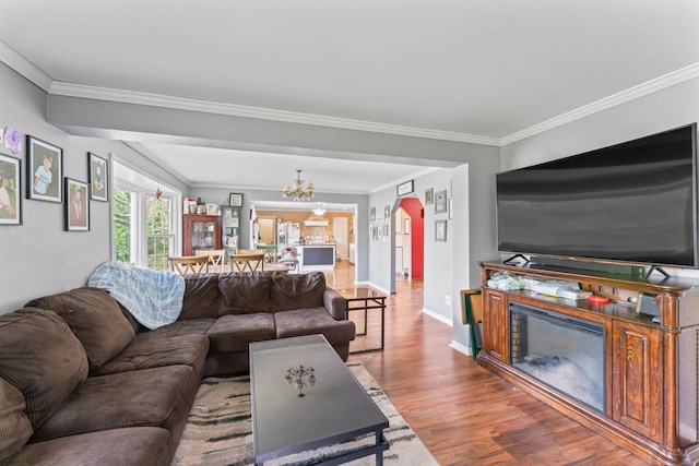 8277 Mccandlish Rd, Grand Blanc, MI 48439 - living area featuring wood finished floors, ornamental molding, baseboards, a chandelier, and arched walkways