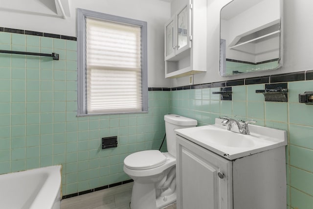 13734 Backus St, Southgate, MI 48195 - bathroom with tile walls, toilet, vanity, a wainscoted wall, and a bathtub