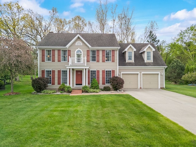 view of front facade with concrete driveway, a front yard, an attached garage, and a shingled roof