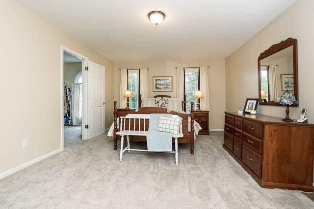 bedroom featuring light colored carpet and baseboards