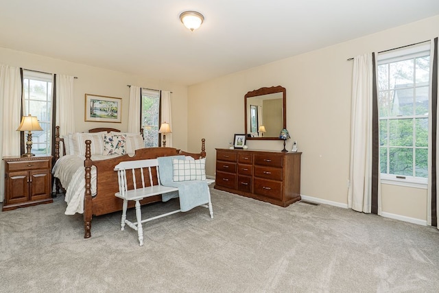 carpeted bedroom with multiple windows and baseboards