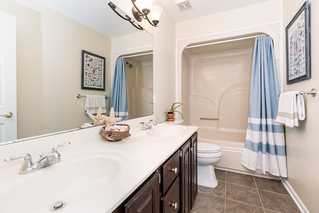 bathroom featuring toilet, shower / bath combo with shower curtain, double vanity, tile patterned flooring, and baseboards