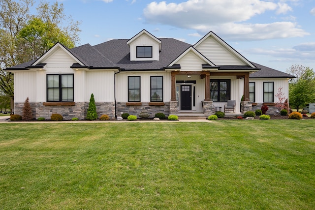 view of front of property featuring stone siding, a porch, and a front yard