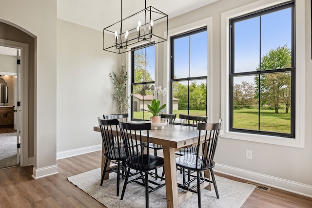 dining space featuring arched walkways, plenty of natural light, and baseboards
