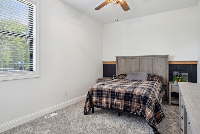 bedroom with carpet, multiple windows, a ceiling fan, and baseboards