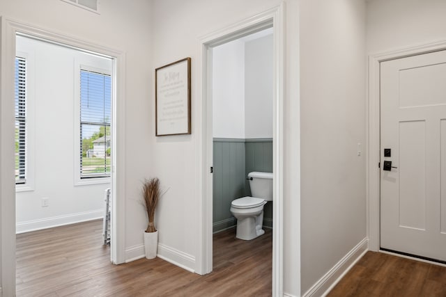 bathroom with wood finished floors, toilet, baseboards, and wainscoting