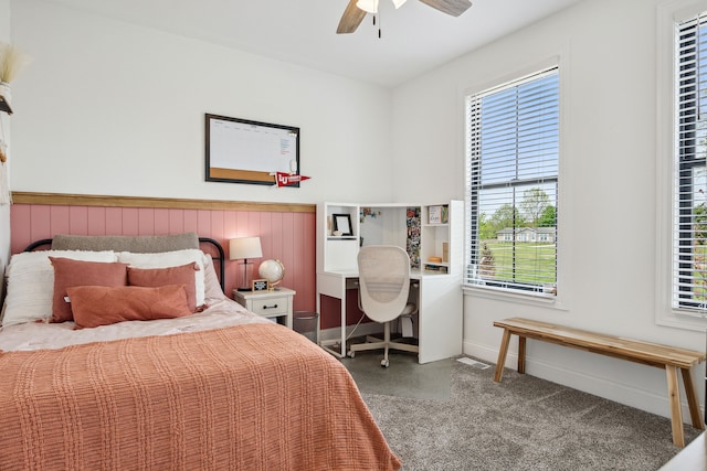 bedroom featuring a wainscoted wall, baseboards, and a ceiling fan