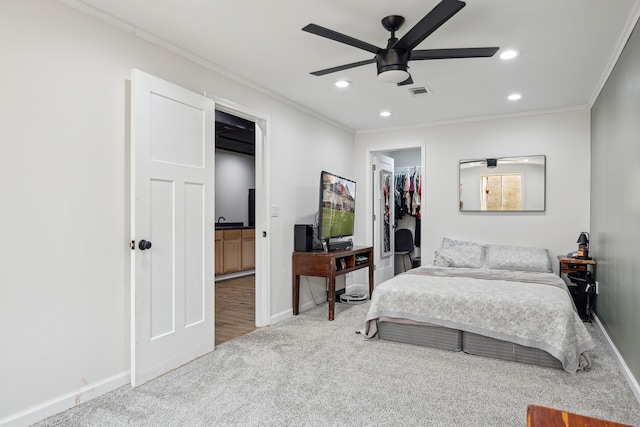 bedroom featuring ornamental molding, carpet, recessed lighting, baseboards, and a walk in closet