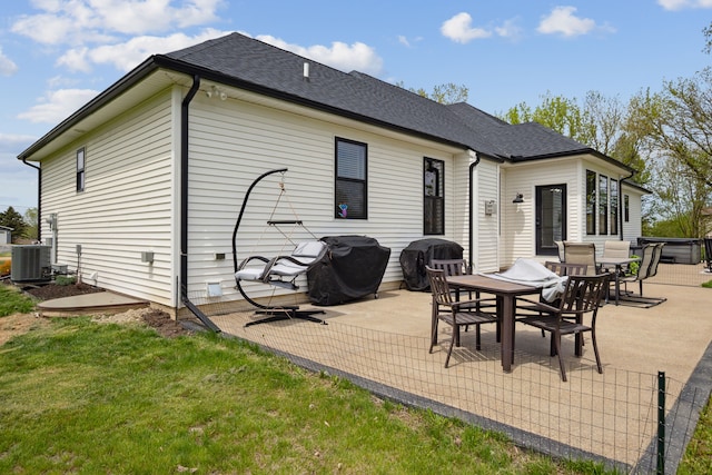 rear view of house with a patio area, a shingled roof, and cooling unit