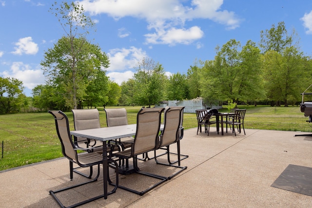 view of patio / terrace featuring outdoor dining area and view of wooded area