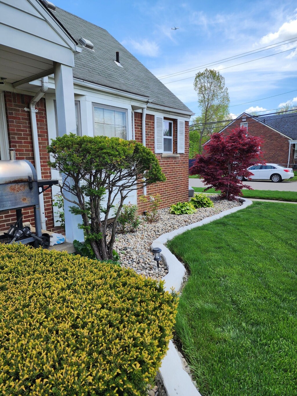 9006 Grandville Ave, Detroit, MI 48228 - view of front of house with brick siding, a front yard, and a shingled roof