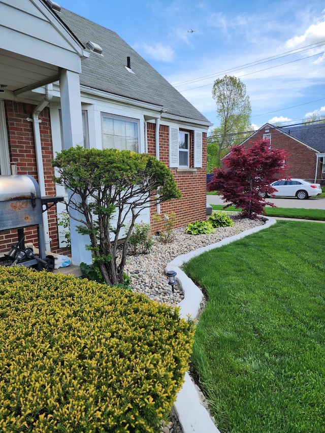 9006 Grandville Ave, Detroit, MI 48228 - view of front of house with brick siding, a front yard, and a shingled roof