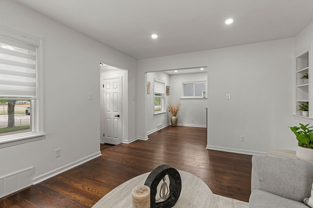 living room with wood finished floors, baseboards, and recessed lighting