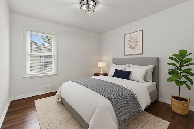 bedroom with baseboards and wood finished floors