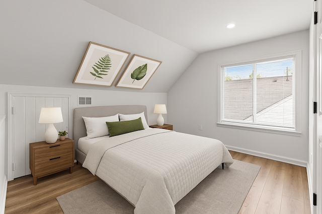 bedroom featuring vaulted ceiling, light wood finished floors, recessed lighting, and baseboards