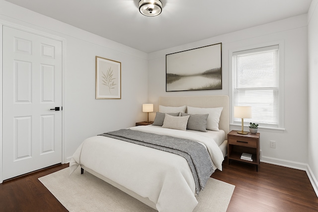 bedroom with dark wood-style flooring and baseboards