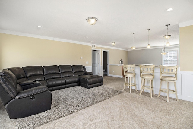 living room with light colored carpet, ornamental molding, a wainscoted wall, and recessed lighting