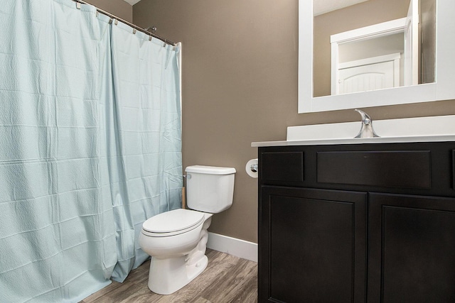 full bathroom with wood finished floors, toilet, baseboards, and vanity
