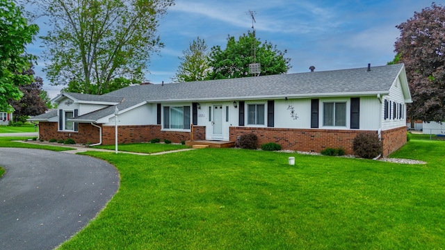 6934 Colonial Dr, Tecumseh, MI 49286 - ranch-style house with brick siding, a front yard, and a shingled roof