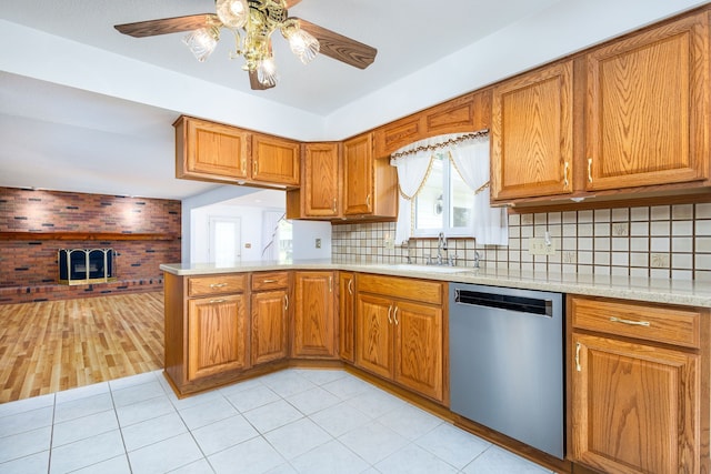 6934 Colonial Dr, Tecumseh, MI 49286 - kitchen with dishwasher, a sink, brown cabinetry, and a peninsula