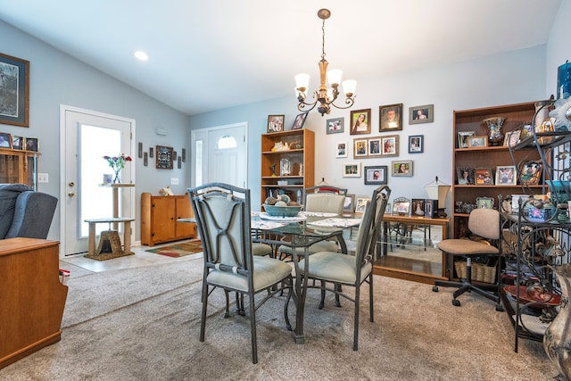 dining area with a chandelier, lofted ceiling, a desk, and carpet