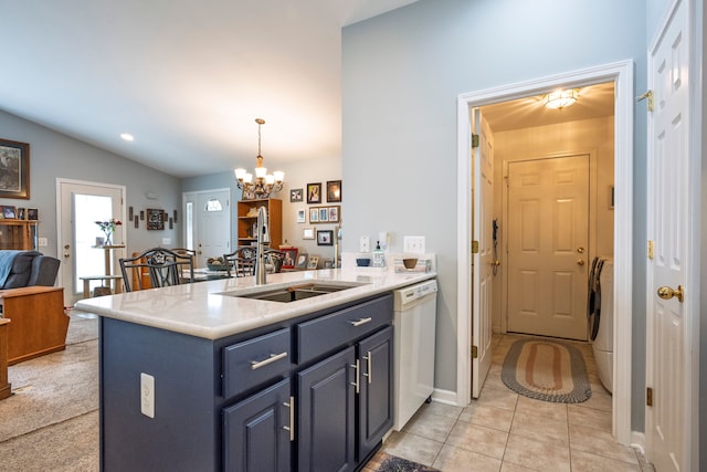 kitchen featuring white dishwasher, a sink, a peninsula, a chandelier, and vaulted ceiling