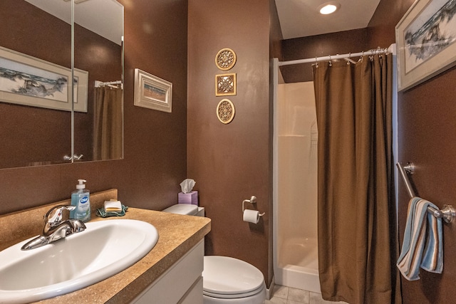 bathroom featuring toilet, a shower stall, vanity, and tile patterned floors