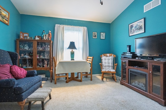 living area with lofted ceiling and carpet