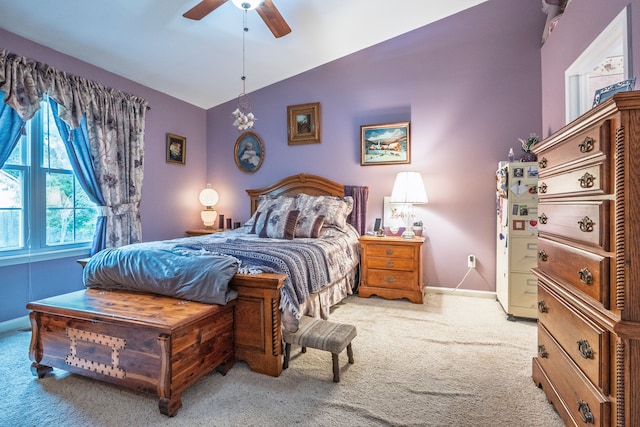 bedroom with light carpet, lofted ceiling, baseboards, and a ceiling fan