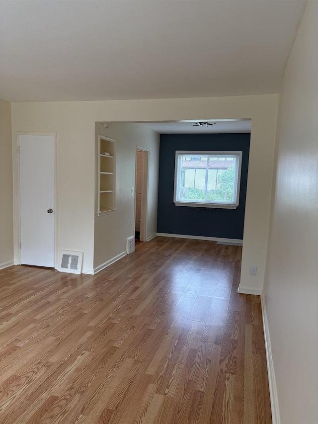 unfurnished room featuring wood finished floors and baseboards