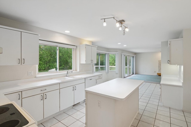 3239 Bellflower Ct, Ann Arbor, MI 48103 - kitchen featuring a sink, light countertops, a center island, light tile patterned floors, and white cabinetry
