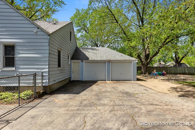 view of side of home with roof with shingles and fence