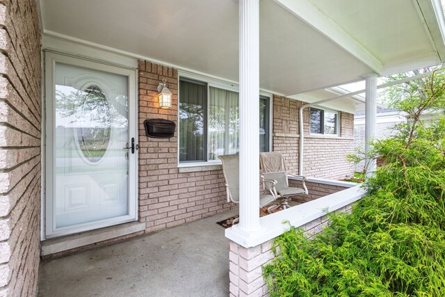 12848 E 14 Mile Rd, Warren, MI 48088 - doorway to property with covered porch and brick siding