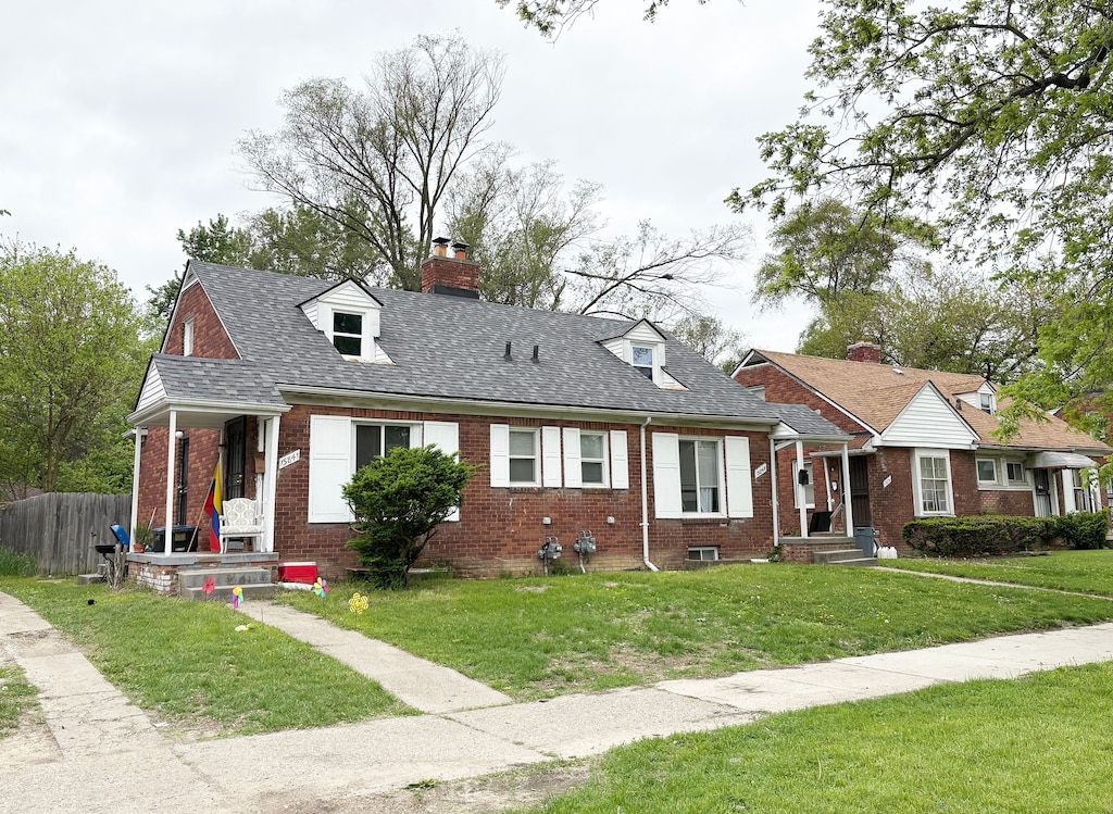 15841 Evergreen Rd, Detroit, MI 48223 - cape cod house with brick siding, a chimney, and roof with shingles