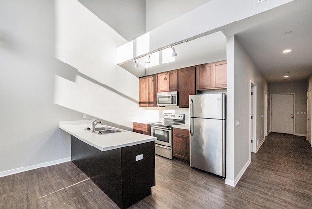600 Douglas St NW Unit 600C, Grand Rapids, MI 49504 - kitchen with stainless steel appliances, a sink, a peninsula, dark wood-style floors, and baseboards